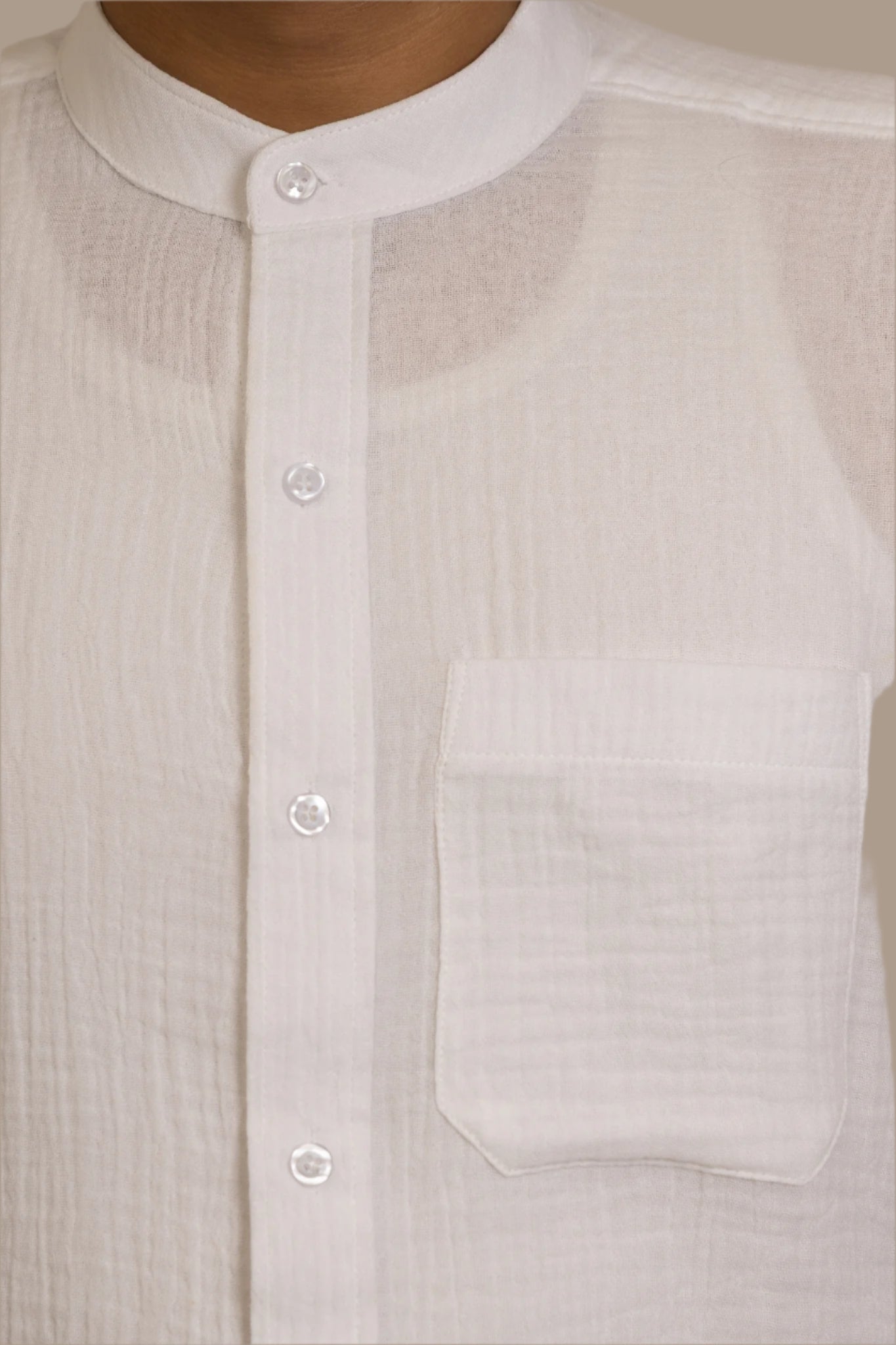 Close-up of a light-colored shirt with buttons and a pocket.